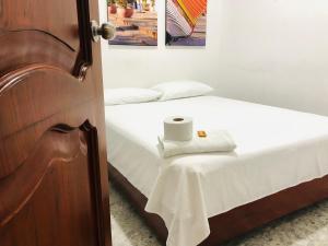 Un dormitorio con una cama con una mesa y una toalla. en Hotel Casa Martina Valledupar, en Valledupar