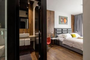 a bedroom with a bed and a bathroom with a sink at Roof 69 Rooms in Split