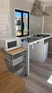 uma cozinha com um micro-ondas e um fogão em Solmeco Park na Aldeia do Meco