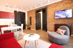 a living room with a red couch and a brick wall at Sarajevo History Apartments in Sarajevo