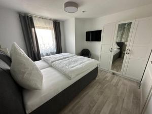 a bedroom with a bed with white sheets and a window at Auszeit Birkenhof in Trimbs