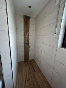 a bathroom with a shower with white walls and wooden floors at Auszeit Birkenhof in Trimbs