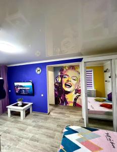 ein Schlafzimmer mit einem Wandbild einer Frau an der Wand in der Unterkunft Яркая квартира в стиле Поп Арт в центре города Караганда in Qaraghandy