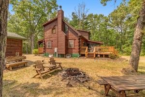 Cabaña de madera con mesas de picnic y fogata en The Birdie Lodge, en Arkdale