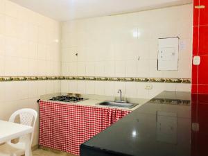 uma cozinha com uma bancada xadrez vermelha e branca em Hotel Casa Martina Valledupar em Valledupar