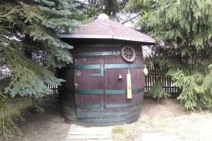 a small wooden out house with a wheel on it at Maciejówka House with a view in Jelenia Góra