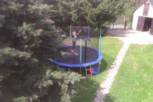 a person is playing on a trampoline in a yard at Maciejówka House with a view in Jelenia Góra