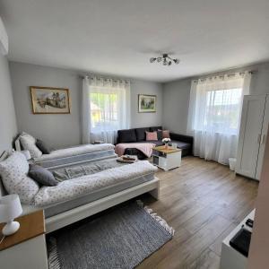 uma sala de estar com uma cama e um sofá em White Luxury Cottage- Mátrai Vadászház 4 em Mátraterenye