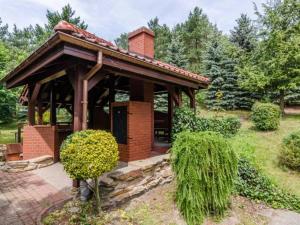 a small brick building with a porch in a garden at Apartament Vip Marysieńka in Kąty Rybackie