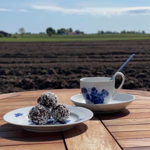 zwei Teller mit schokoladenüberzogenen Donuts und eine Tasse Kaffee in der Unterkunft Peppinge Bed & Breakfast in Löderup