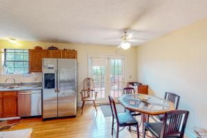 a kitchen with a table and a stainless steel refrigerator at East End Harmony Retro Retreat in Nashville