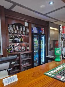 a bar with a cash register and bottles of alcohol at The Raceby Hotel, Doncaster South Yorkshire, Part of the AG Collection in Doncaster