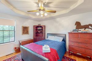 a bedroom with a bed with a ceiling fan and a dresser at East End Harmony Retro Retreat in Nashville