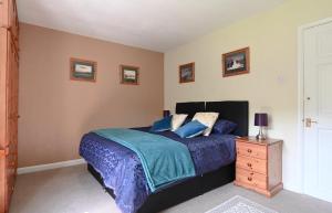 ein Schlafzimmer mit einem Bett und einer Holzkommode in der Unterkunft Riverside B&B in Moretonhampstead