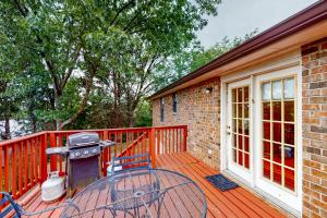 a grill on a wooden deck next to a house at East End Harmony Retro Retreat in Nashville