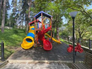 a playground in a park with a slide at Мансарда с верандой in Borjomi