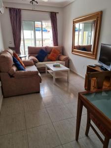 sala de estar con sofá y TV en Luz de almoradi, en Almoradí