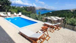 a swimming pool with chaise lounge chairs and a swimming pool at Villa Panama in Pag