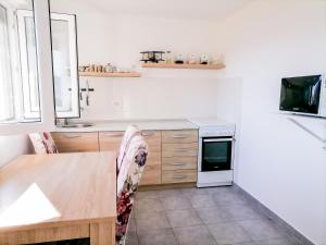 a kitchen with a wooden table and a stove top oven at Apartments Siesta in Tivat