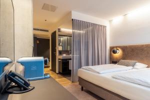 pokój hotelowy z łóżkiem i telefonem w obiekcie arte Hotel Salzburg w mieście Salzburg