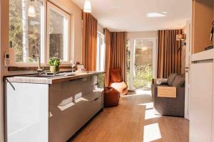 a kitchen with a sink and a living room at Fridis&Chill in Sigulda