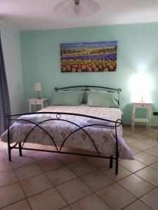 um quarto com uma cama com um quadro na parede em B&B Ortensia em Cava deʼ Tirreni