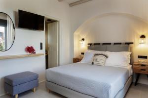 a bedroom with a white bed and a mirror at Aesthete Suites in Agia Anna Naxos