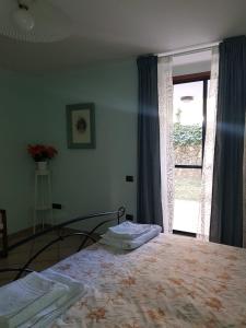 een slaapkamer met een bed voor een raam bij B&B Ortensia in Cava deʼ Tirreni