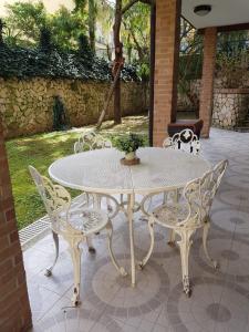 een witte tafel en stoelen op een patio bij B&B Ortensia in Cava deʼ Tirreni