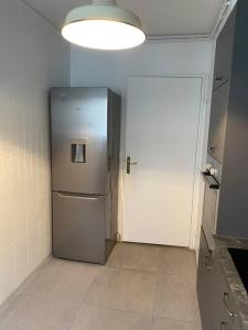 a silver refrigerator in a kitchen with a light at Suresnes’s Center in Suresnes