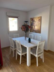 a white dining room table with chairs and a vase on it at Suresnes’s Center in Suresnes