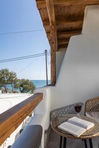 een balkon met een tafel en uitzicht op de oceaan bij Aesthete Suites in Agia Anna Naxos