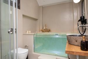 een badkamer met een zwembad in een douche bij Aesthete Suites in Agia Anna Naxos