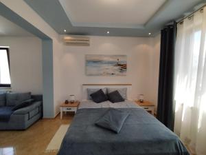 een slaapkamer met een groot bed en een bank bij Oli Umag in Umag