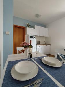 een tafel met twee borden en een fles wijn bij Oli Umag in Umag