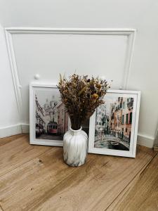 two framed photographs and a white vase with flowers in it at Joli Studio sur le Port in Cannes
