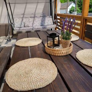 a deck with three baskets and a bench and flowers at White Luxury Cottage- Mátrai Vadászház 4 in Mátraterenye