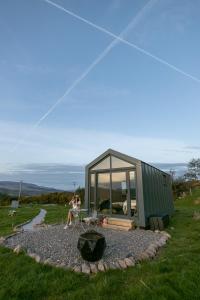 a woman is flying a kite in front of a tiny house at Oaklane Glamping Cabins in Kenmare
