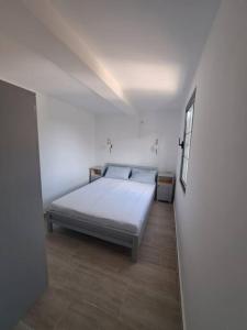 ein Schlafzimmer mit einem Bett in einem weißen Zimmer in der Unterkunft Once Upon a Time in Montenegro in Sutomore