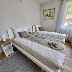 a bedroom with two beds and a window at White Luxury Cottage- Mátrai Vadászház 4 in Mátraterenye