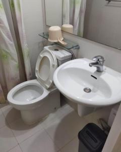 a bathroom with a white toilet and a sink at Room at SM Bicutan with Balcony in Manila