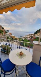 un tavolo e sedie su un balcone con vista sull'oceano di Villa Celentano a Positano