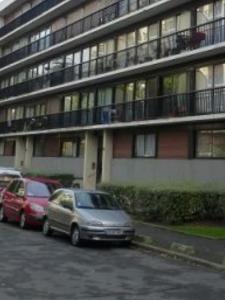 zwei Autos auf einem Parkplatz vor einem Gebäude geparkt in der Unterkunft Spacieux et confortable appartement en résidence in Pontoise