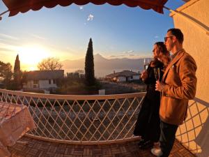een man en een vrouw op een balkon met uitzicht op de zonsondergang bij Garda Panoramic House in Albisano