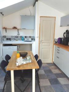 una pequeña cocina con mesa de madera y sillas en Maisonnette avec terrasse privative, en La Ciotat