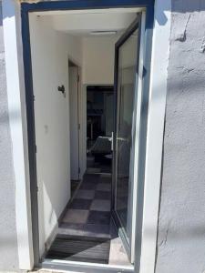 un couloir avec une porte en verre et un sol en damier dans l'établissement Maisonnette avec terrasse privative, à La Ciotat