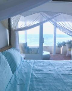 a bedroom with a bed with a view of the ocean at CasaDePlaya Cabarete Beachfront in Cabarete