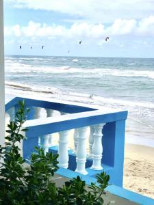 a blue bench on the beach with kites in the sky at CasaDePlaya Cabarete Beachfront in Cabarete