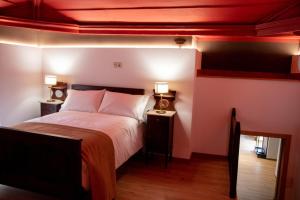 雷阿爾城的住宿－Casa De Quintãs，一间卧室配有一张床和两张台灯。