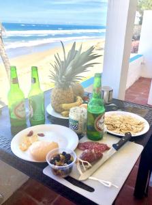 a table with plates of food and bottles of beer at CasaDePlaya Cabarete Beachfront in Cabarete